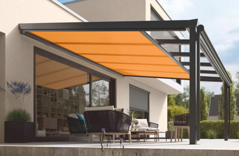 Terrasoverkapping met oranje onderglaszonwering boven een loungeset op het terras