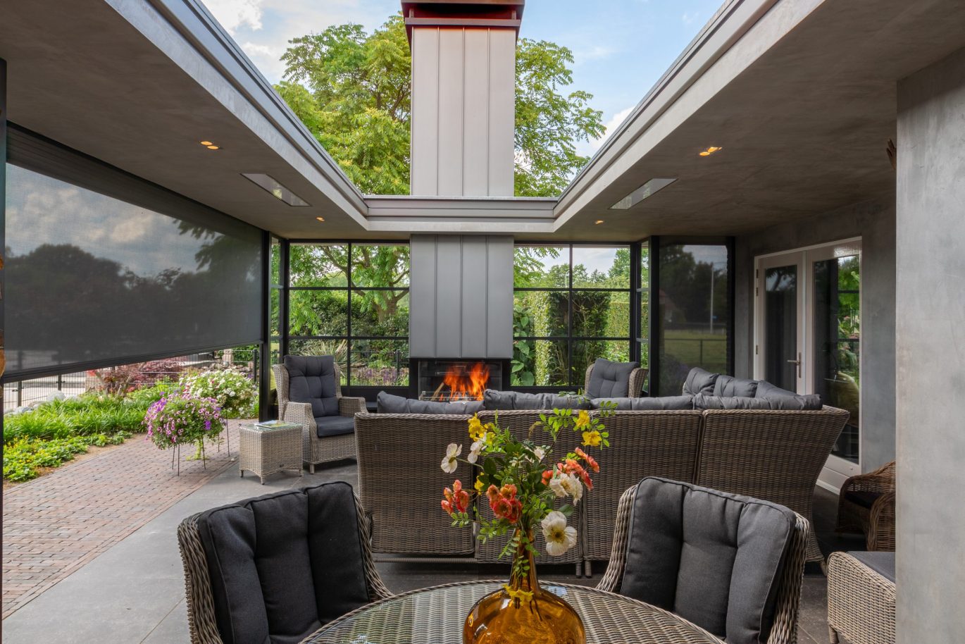 Luxe buitenruimte met glasconstructie, haard en stalen draagconstructie.